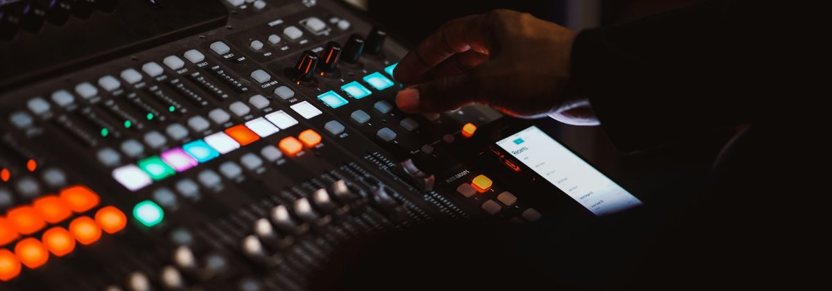 Hand adjusting the gain control on a studio audio interface