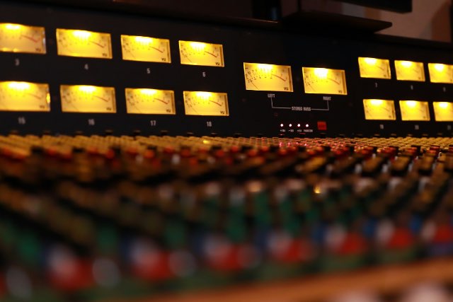 Audio mixer board showing podcast music settings