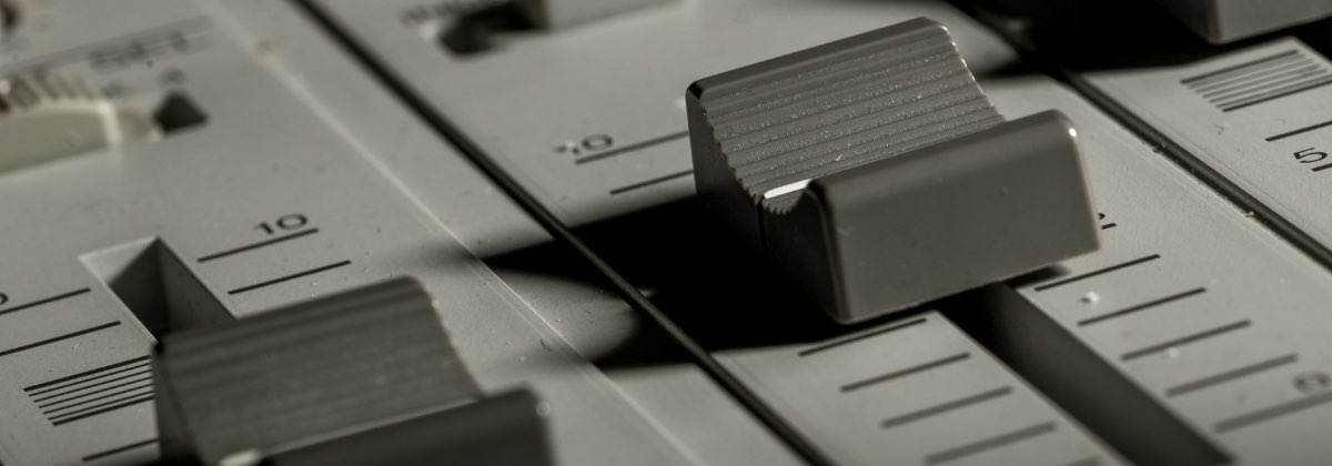 A professional DJ mixer focusing on the central crossfader slider