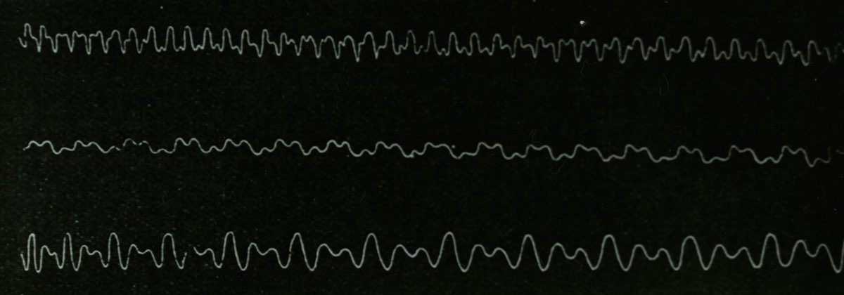 A digital oscilloscope screen showing a bright green sine wave