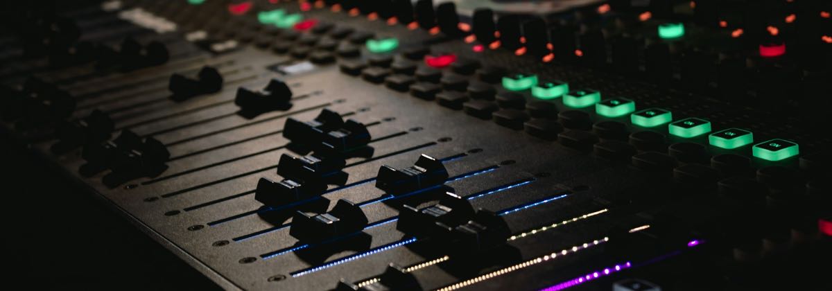 Illuminated audio mixing console used to normalize audio volume and control gain without clipping