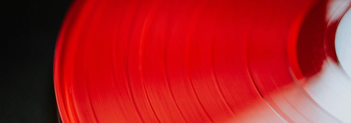 Plattenspieler mit einer roten Vinylplatte, der zeigt, wie eine langsamere Abspielgeschwindigkeit die Tonhöhe eines Songs senkt