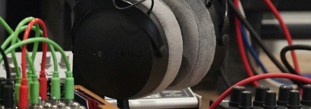 Audio engineer wearing studio headphones focusing on mixing console